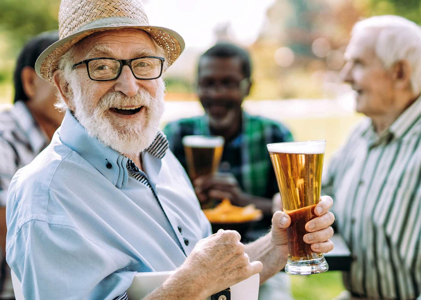 four older gentlemen laughing and talking over a beer