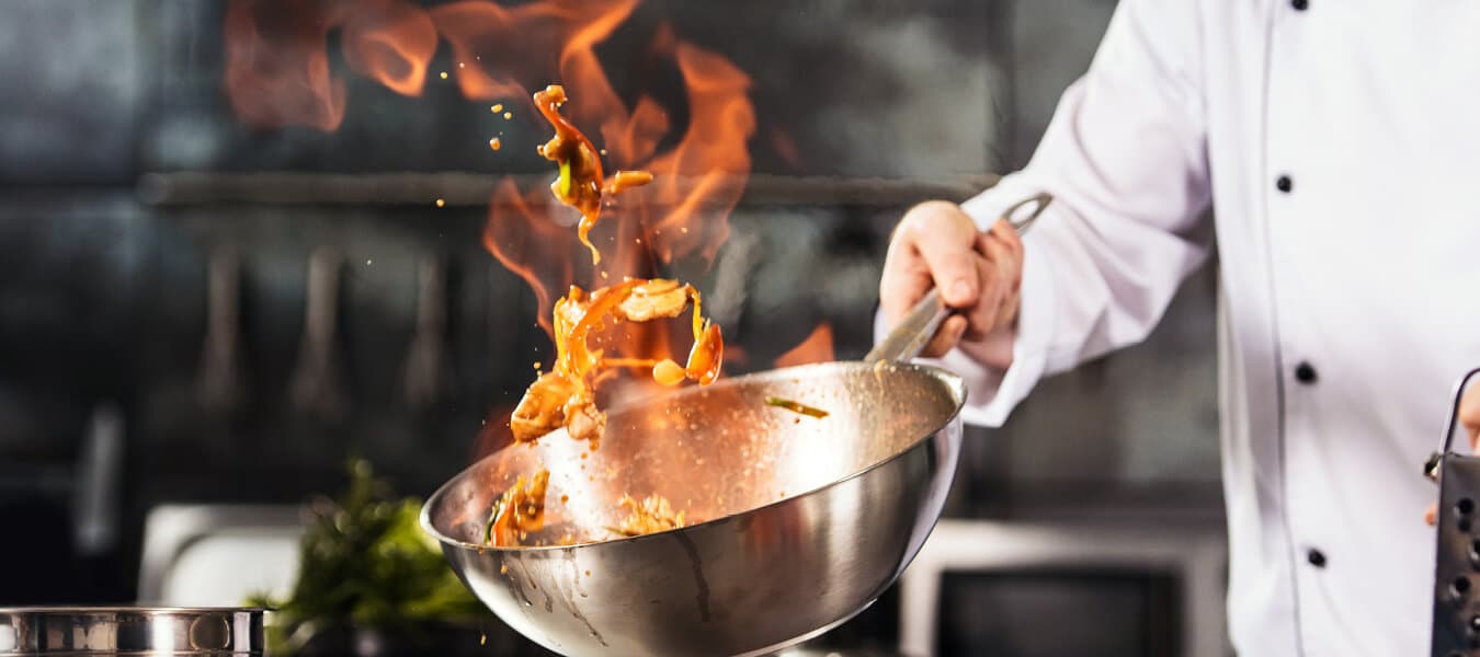 Chef flambéing in a wok